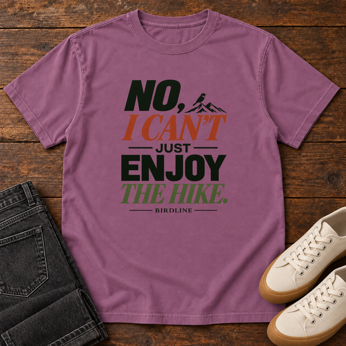 No I Can't Just Enjoy the Hike T-Shirt – Color Block in Berry, front laid flat on wood, featuring stacked green and rust slogan lettering and a small mountain graphic.