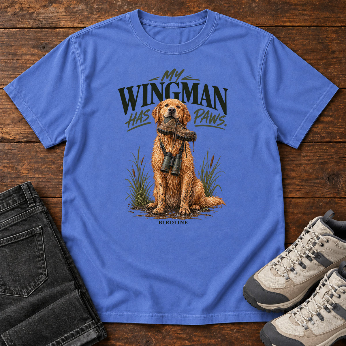 Mystic Blue My Wingman Has Paws Retriever T-Shirt with a seated golden dog wearing binoculars beneath the slogan, front flat lay on wood.