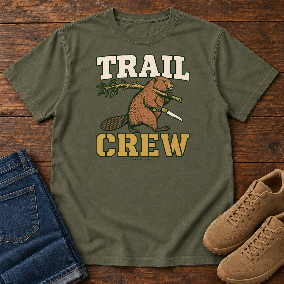 Sage Trail Crew Foreman T-Shirt with a beaver carrying a leafy branch and saw beneath Trail Crew lettering; front flat lay on wood.