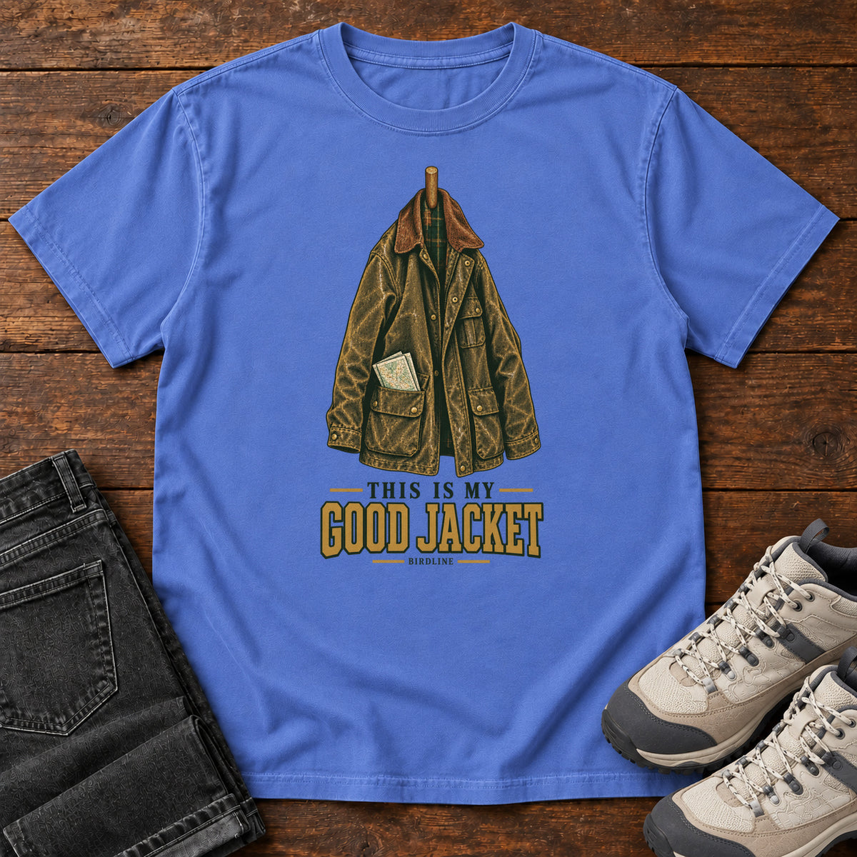 Mystic Blue This Is My Good Jacket T-Shirt with a hanging outdoor jacket and This Is My Good Jacket lettering; front flat lay on wood.