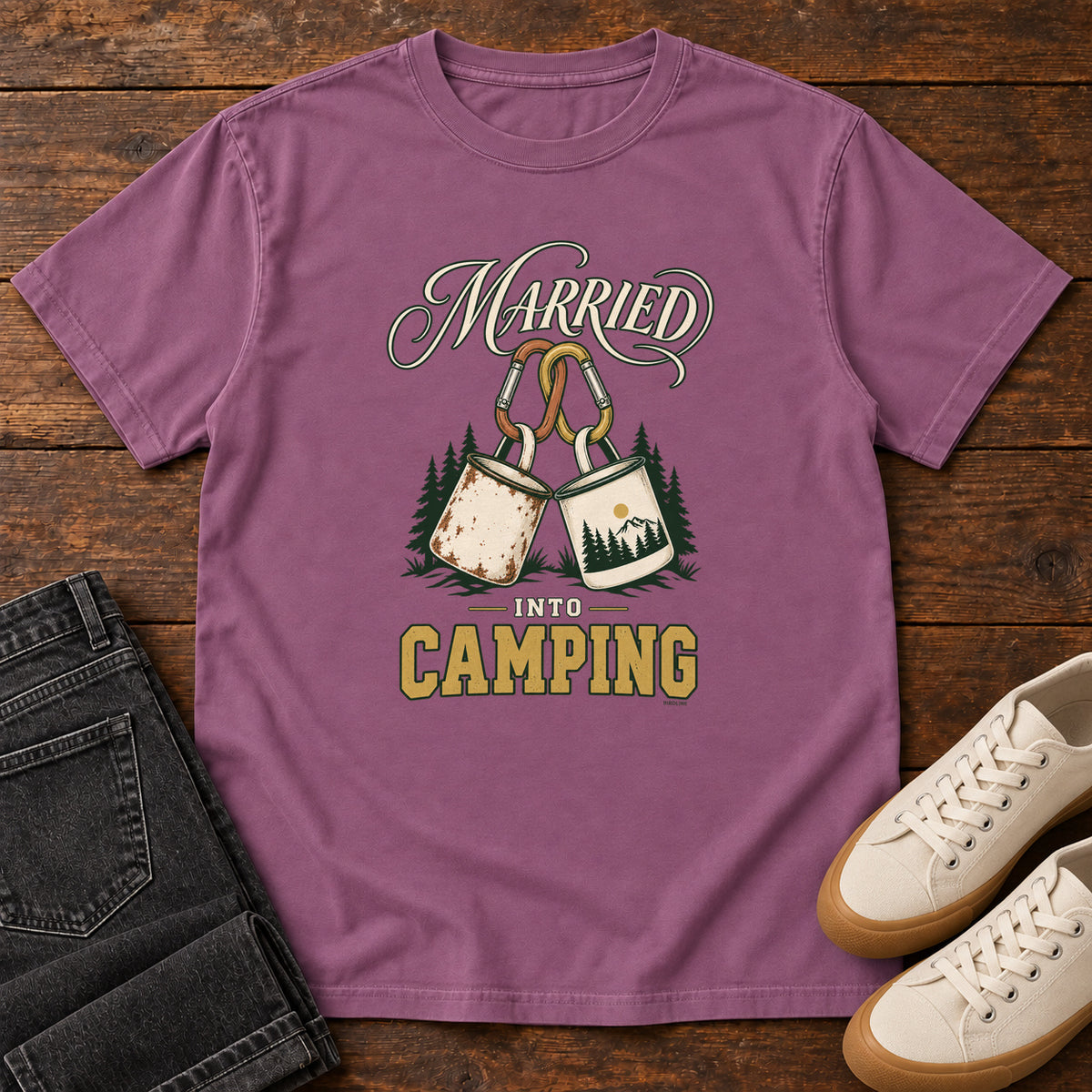 Berry Married into Camping T-Shirt with two camp mugs hanging from carabiners between cream and gold lettering, front flat lay on wood.