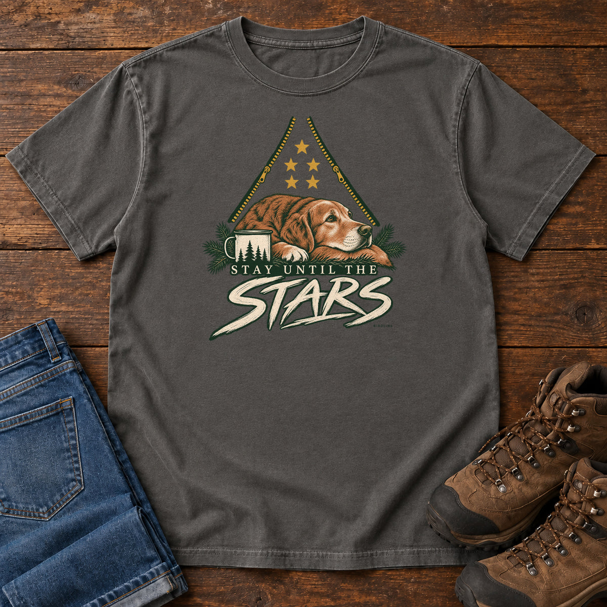 Pepper Stay Until the Stars T-Shirt with a resting brown dog beside a camp mug beneath gold stars and cream lettering, front flat lay on wood.