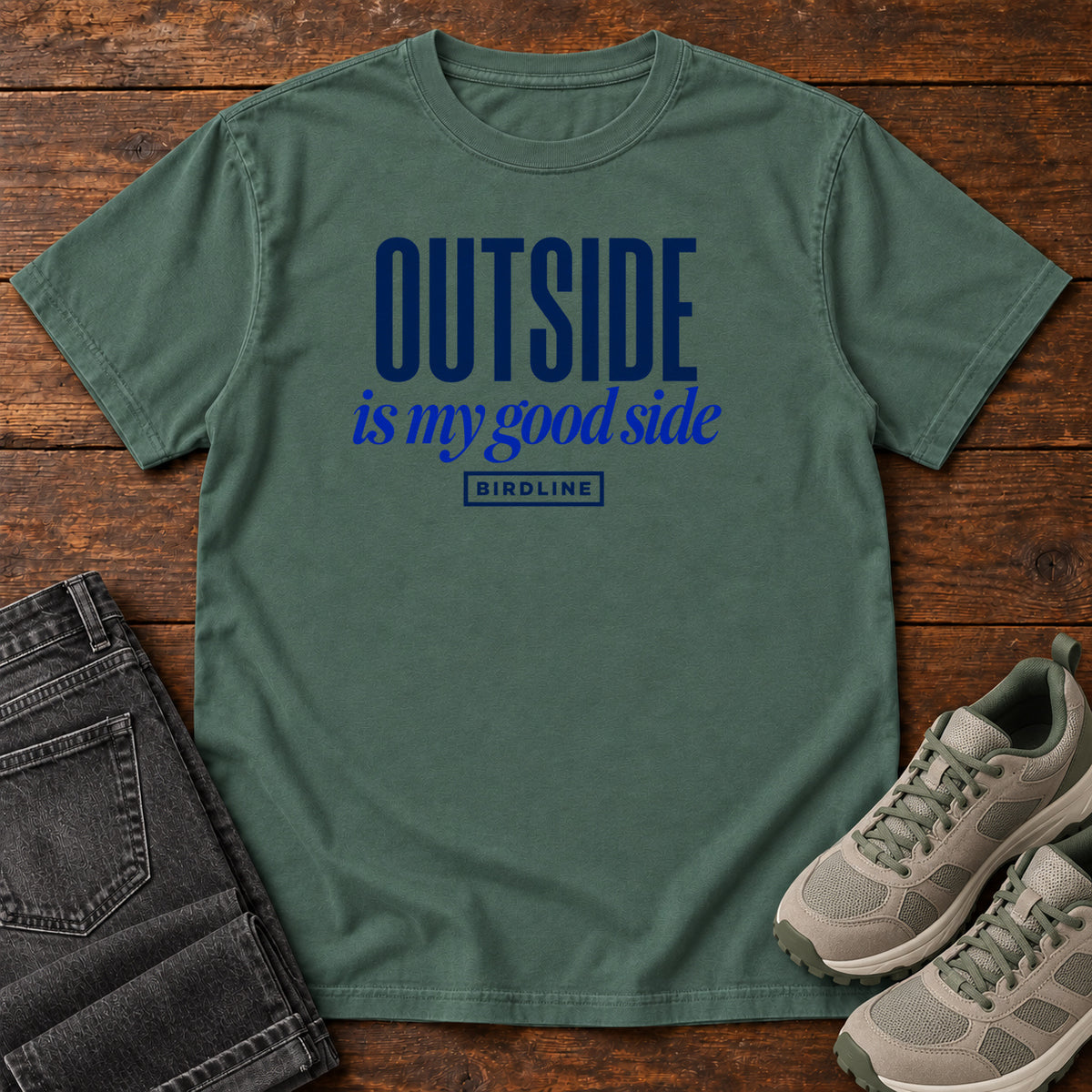 Blue Spruce Outside Is My Good Side T-Shirt with dark blue block-and-script lettering, front flat lay on wood.