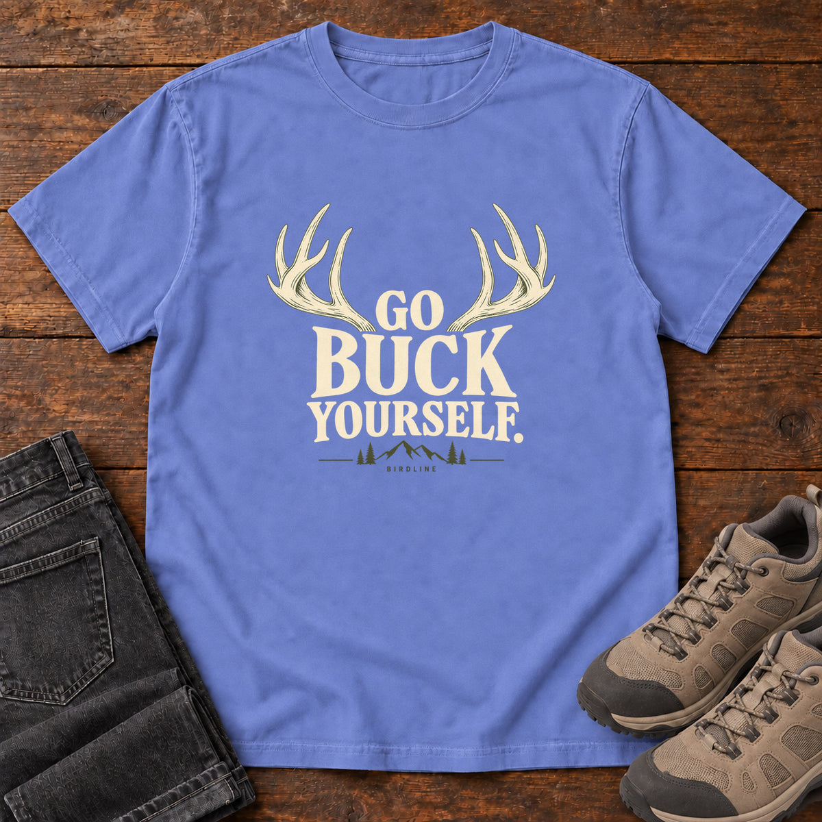 Flo Blue Go Buck Yourself T-Shirt with cream deer antlers framing Go Buck Yourself lettering, front flat lay on wood.