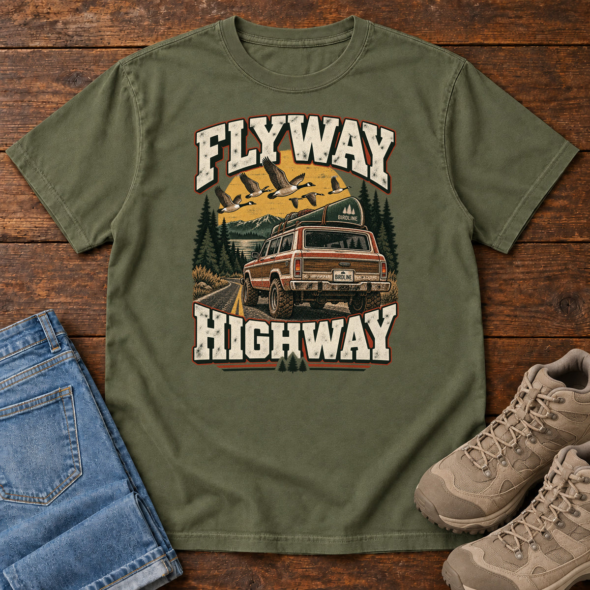 Hemp Flyway Highway T-Shirt with a vintage pickup on a forest road with flying birds overhead; front flat lay on wood.