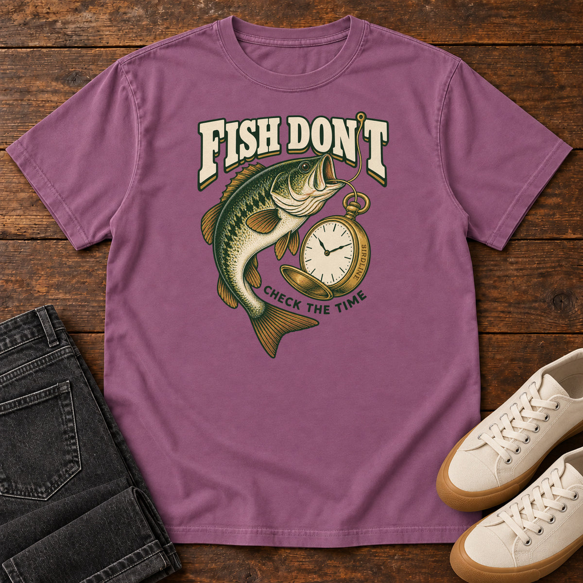 Berry Fish Don't Check the Time T-Shirt with a green fish curving beside an open gold pocket watch; front flat lay on wood.