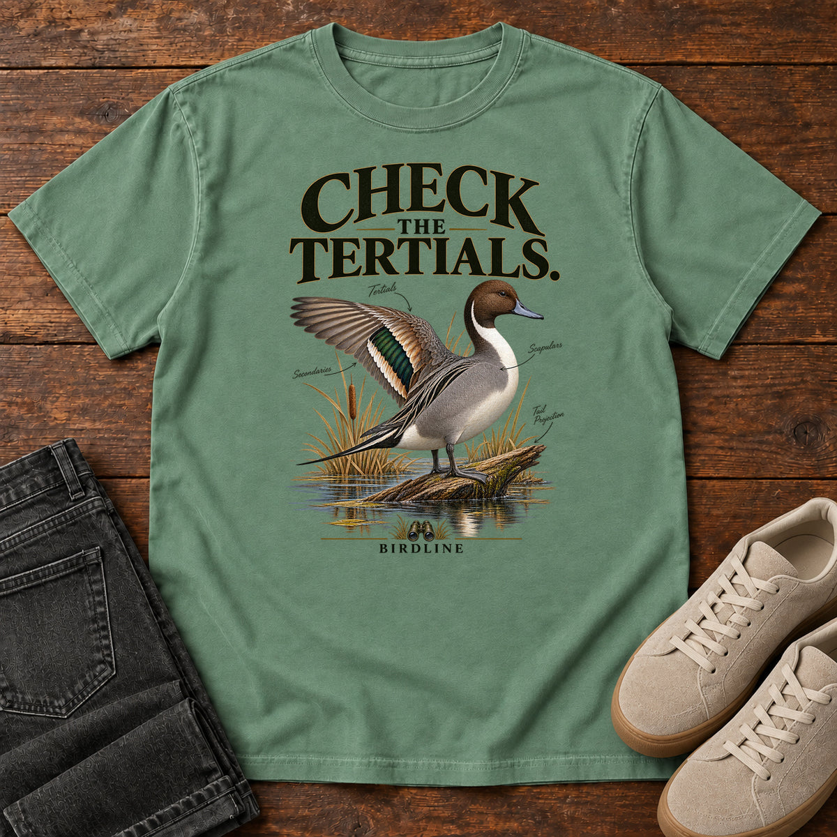 Light Green Check the Tertials Duck T-Shirt with a duck raising one wing beside reeds and water; front flat lay on wood.
