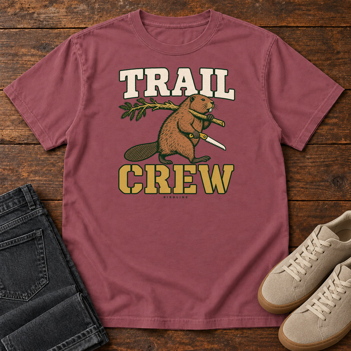 Brick Trail Crew Foreman T-Shirt with a beaver carrying a leafy branch and saw beneath Trail Crew lettering; front flat lay on wood.