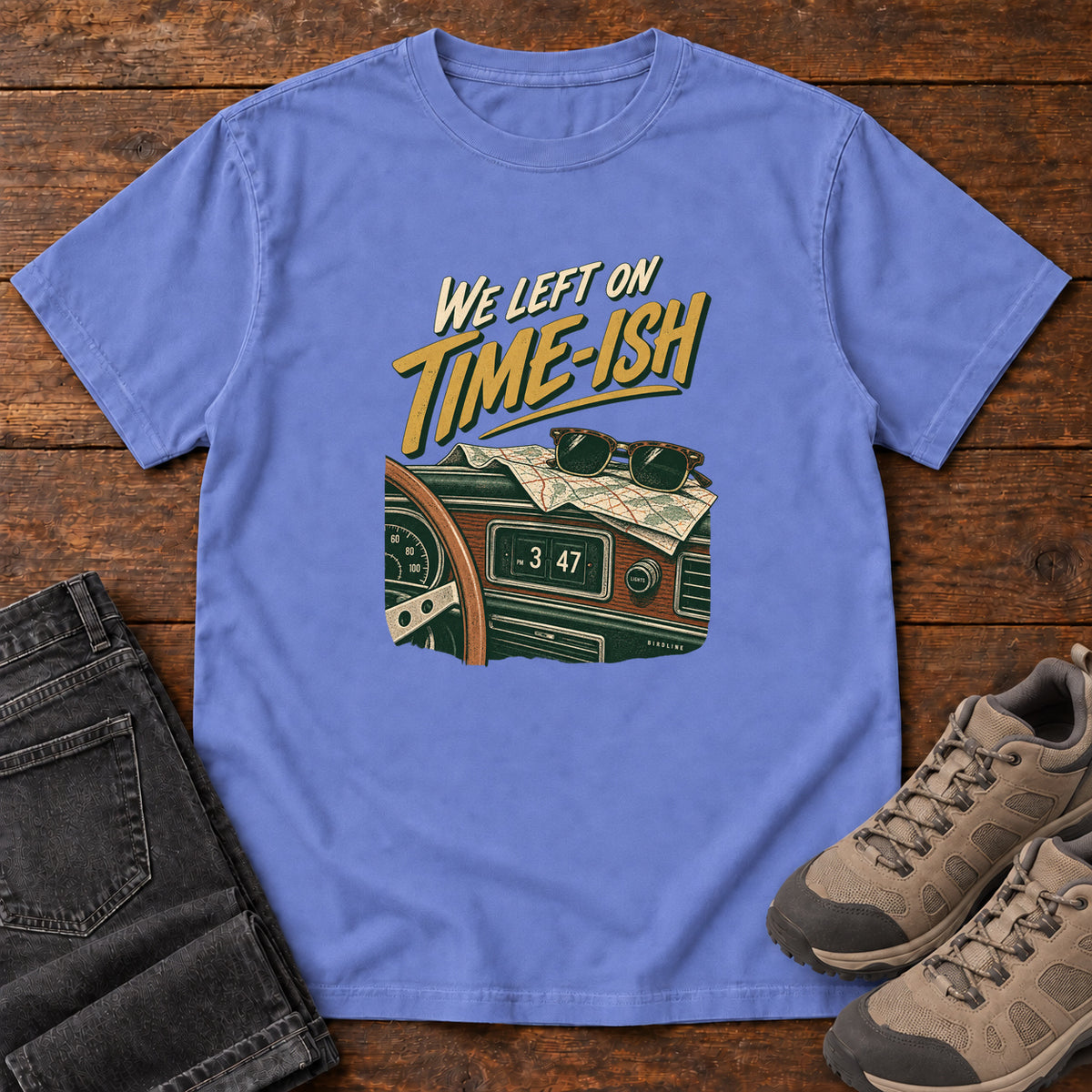 Flo Blue We Left on Time-Ish T-Shirt with a retro dashboard, folded map and sunglasses; front flat lay on wood.