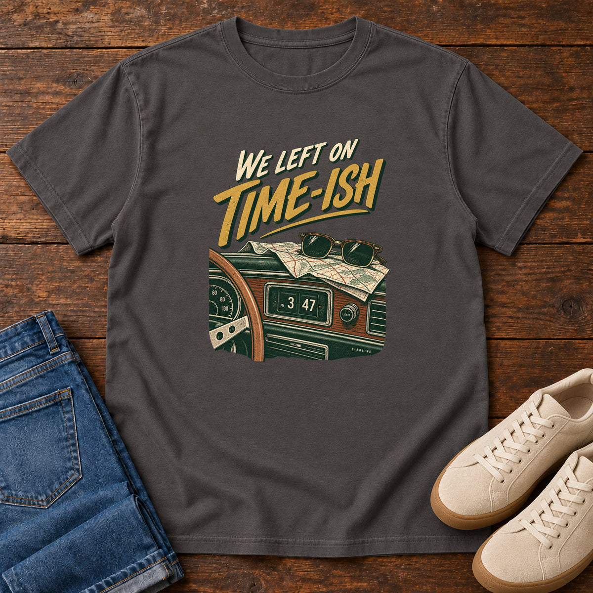 Graphite We Left on Time-Ish T-Shirt with a retro dashboard, folded map and sunglasses; front flat lay on wood.