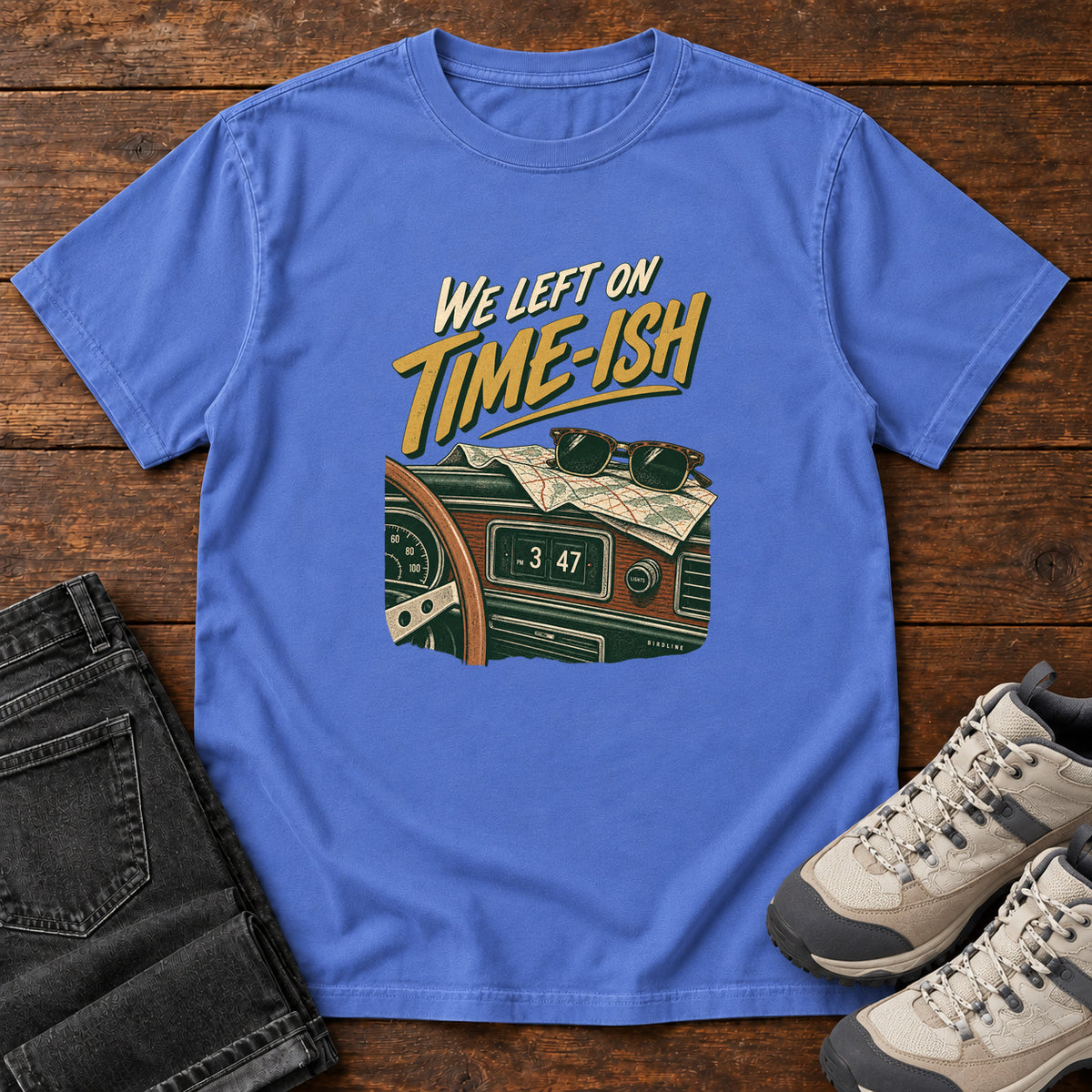 Mystic Blue We Left on Time-Ish T-Shirt with a retro dashboard, folded map and sunglasses; front flat lay on wood.