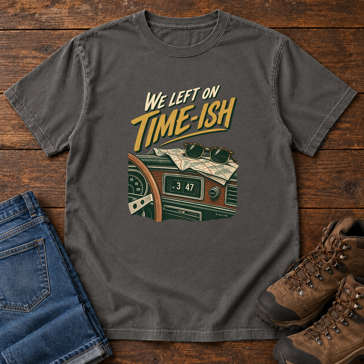 Pepper We Left on Time-Ish T-Shirt with a retro dashboard, folded map and sunglasses; front flat lay on wood.