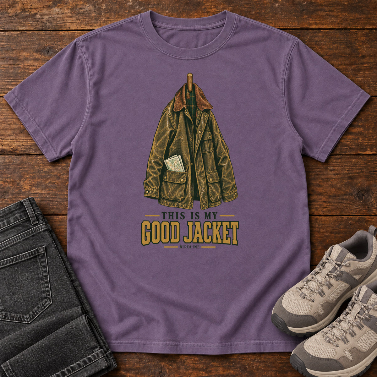 Grape This Is My Good Jacket T-Shirt with a hanging outdoor jacket and This Is My Good Jacket lettering; front flat lay on wood.