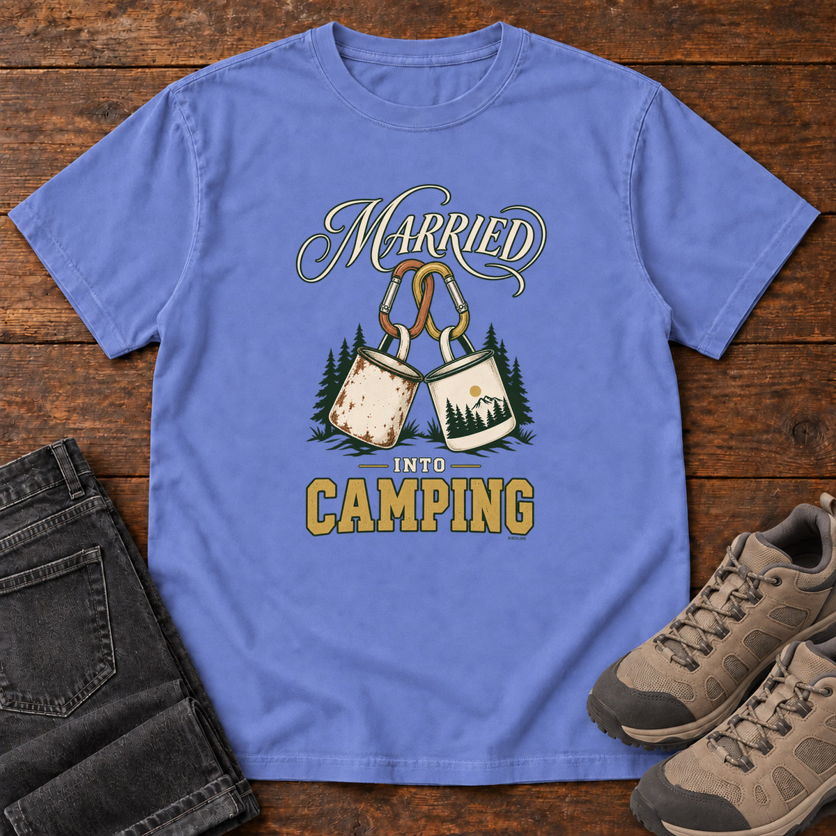 Flo Blue Married into Camping T-Shirt with two camp mugs hanging from carabiners between cream and gold lettering, front flat lay on wood.