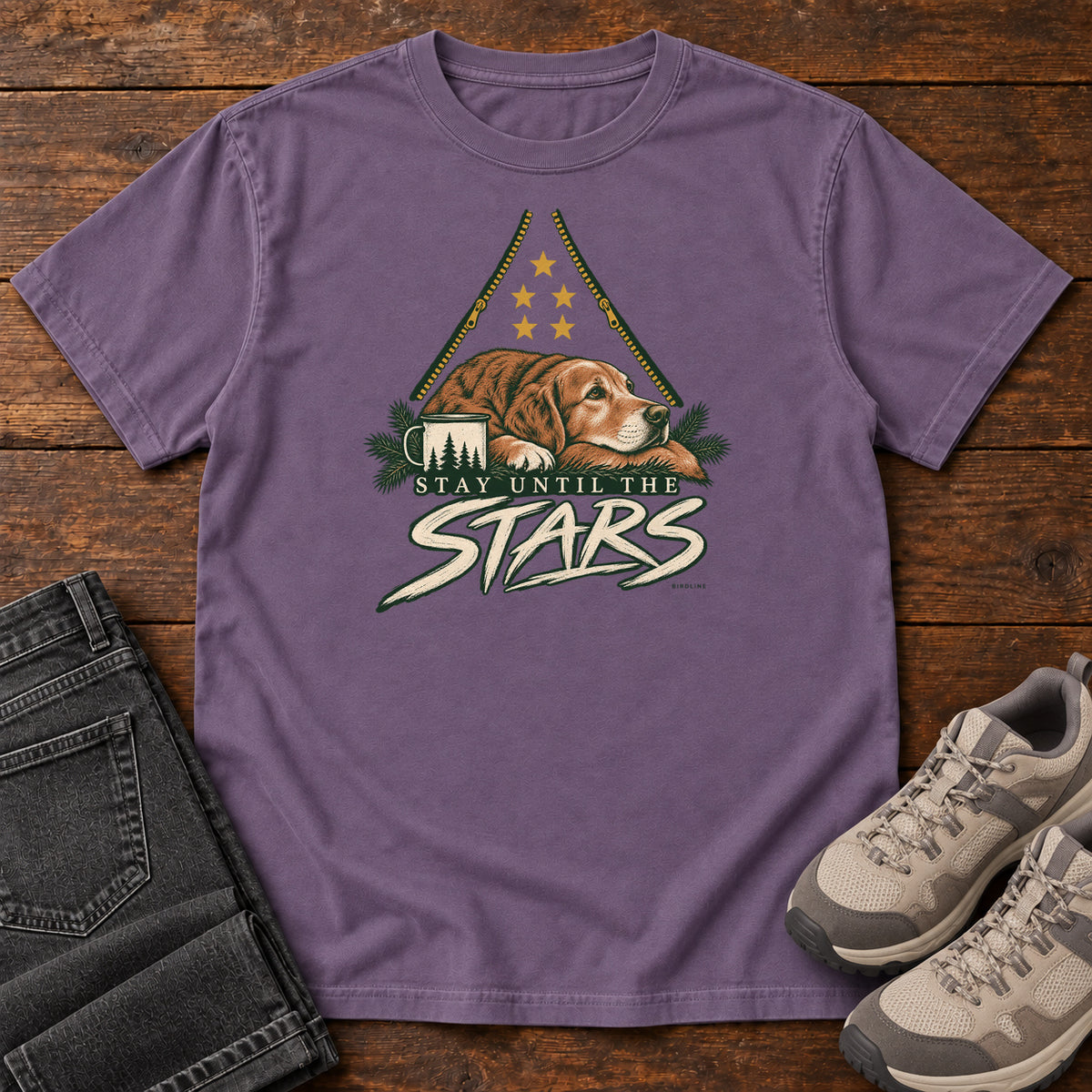 Grape Stay Until the Stars T-Shirt with a resting brown dog beside a camp mug beneath gold stars and cream lettering, front flat lay on wood.