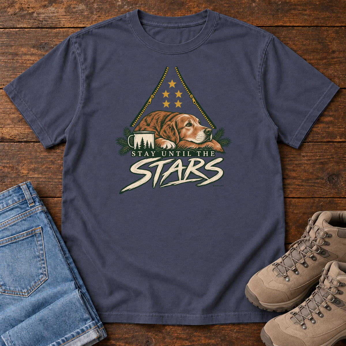 Navy Stay Until the Stars T-Shirt with a resting brown dog beside a camp mug beneath gold stars and cream lettering, front flat lay on wood.