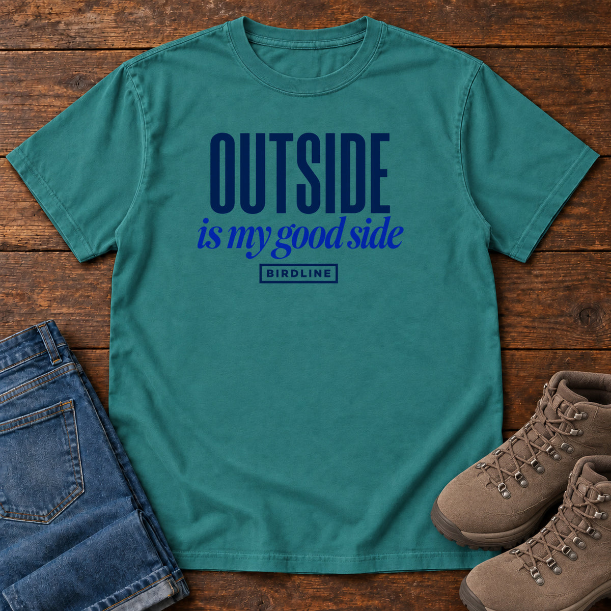 Emerald Outside Is My Good Side T-Shirt with dark blue block-and-script lettering, front flat lay on wood.
