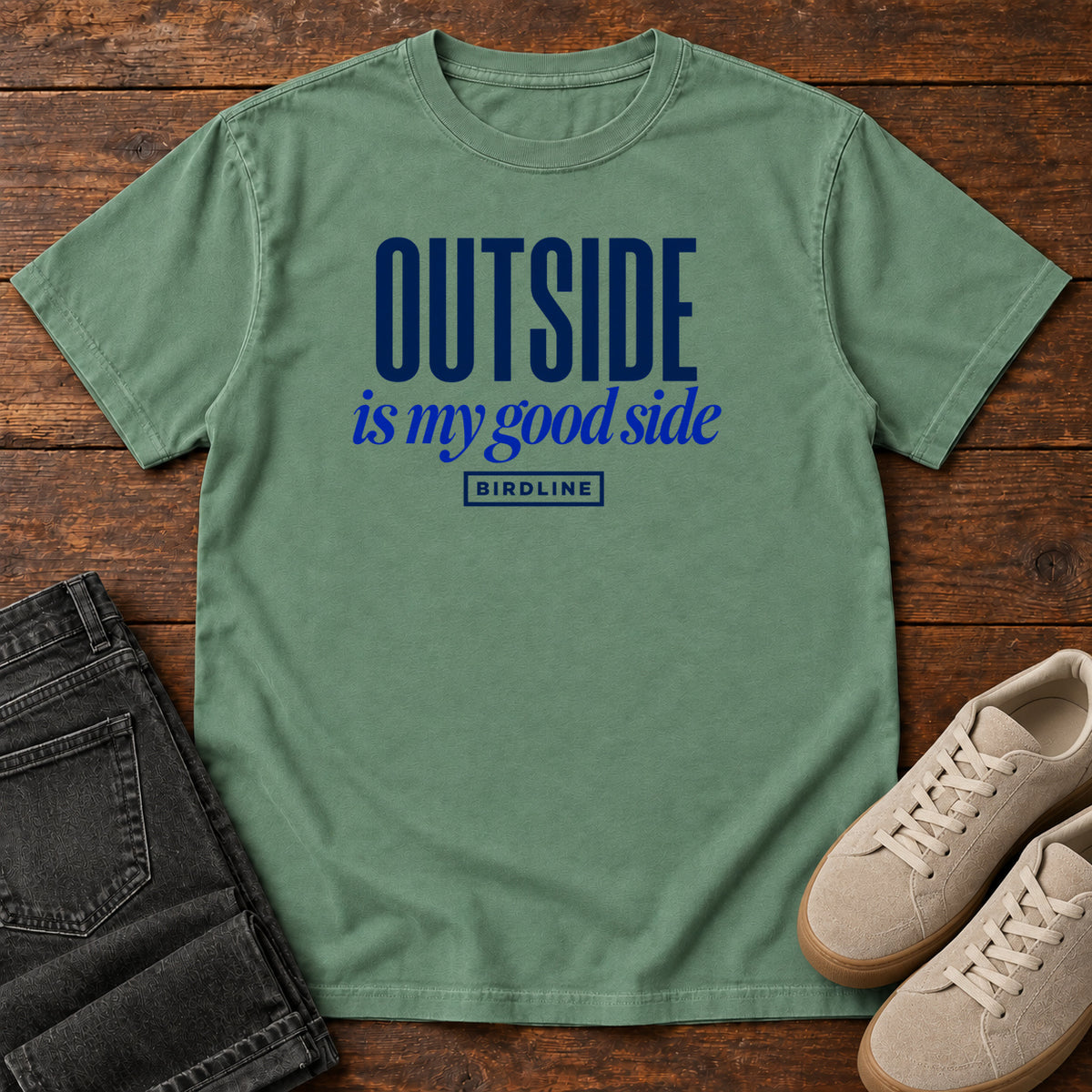 Light Green Outside Is My Good Side T-Shirt with dark blue block-and-script lettering, front flat lay on wood.