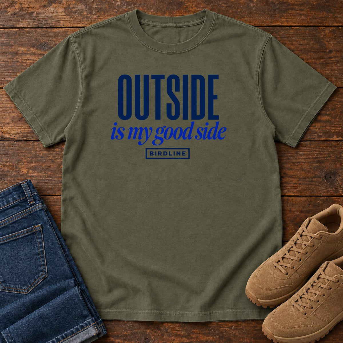 Sage Outside Is My Good Side T-Shirt with dark blue block-and-script lettering, front flat lay on wood.