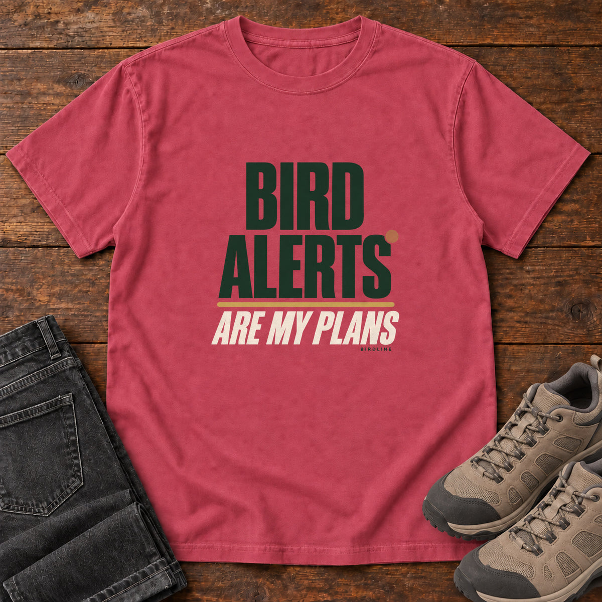 Paprika Bird Alerts Are My Plans T-Shirt with stacked green-and-cream lettering and an orange accent; front flat lay on wood.