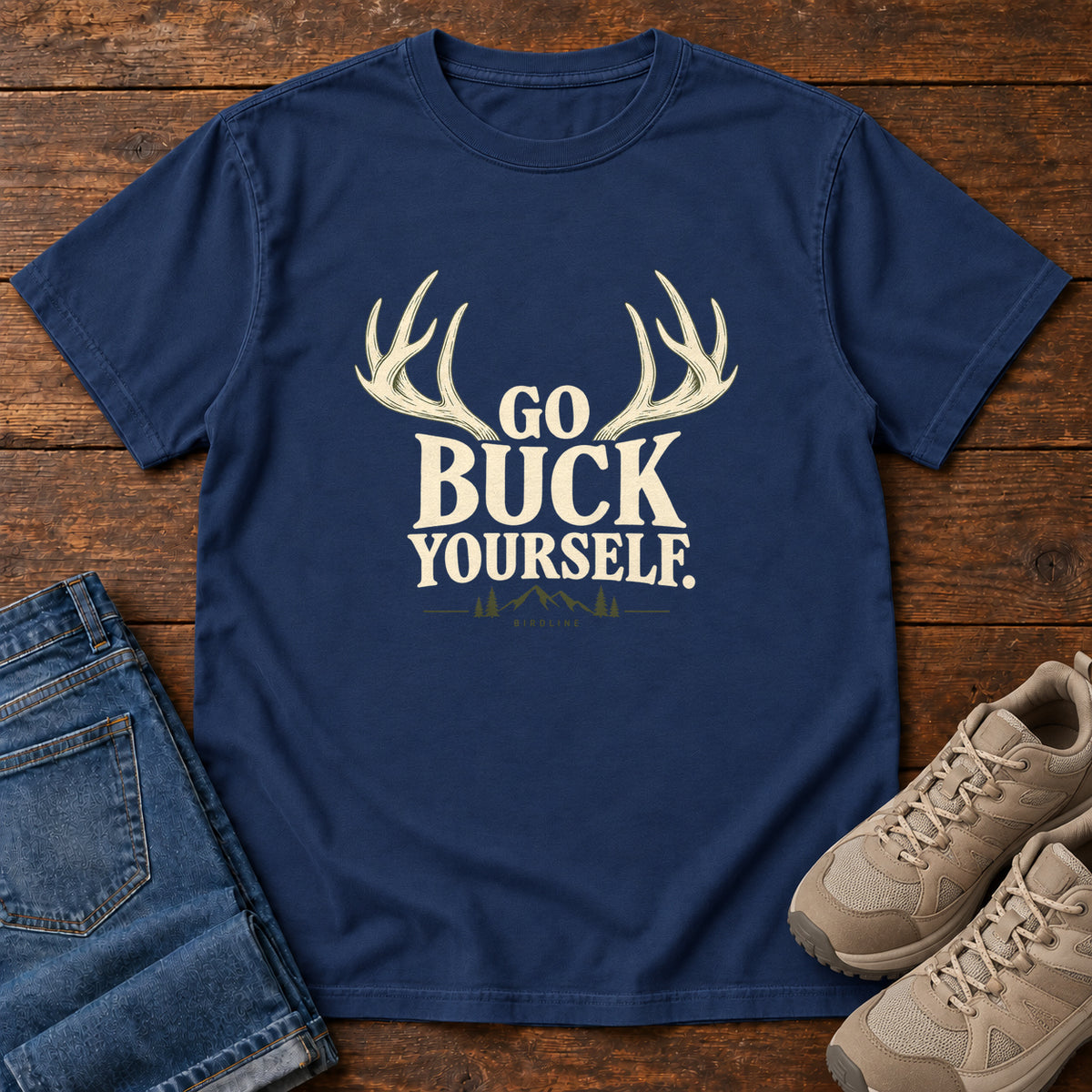 True Navy Go Buck Yourself T-Shirt with cream deer antlers framing Go Buck Yourself lettering, front flat lay on wood.