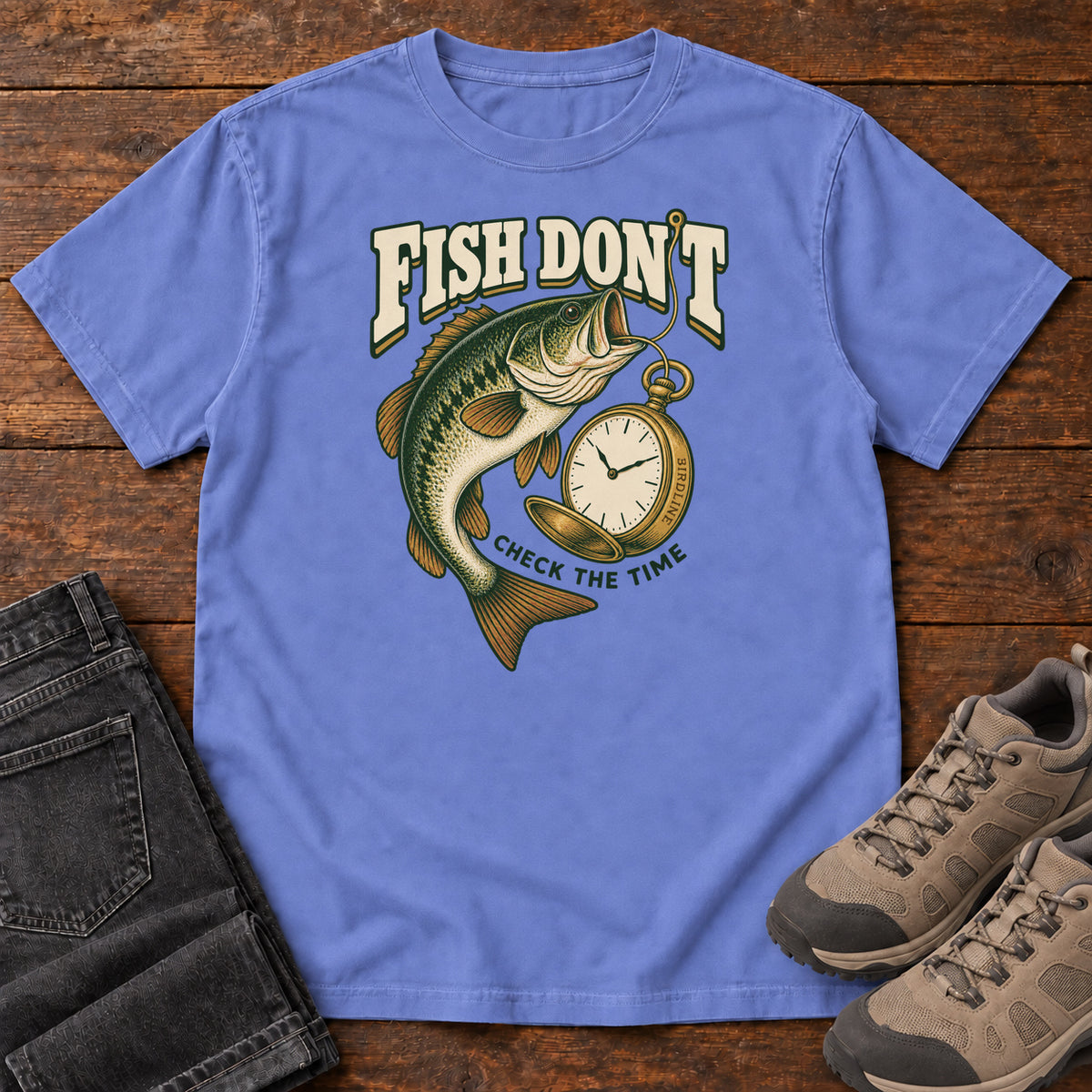 Flo Blue Fish Don't Check the Time T-Shirt with a green fish curving beside an open gold pocket watch; front flat lay on wood.