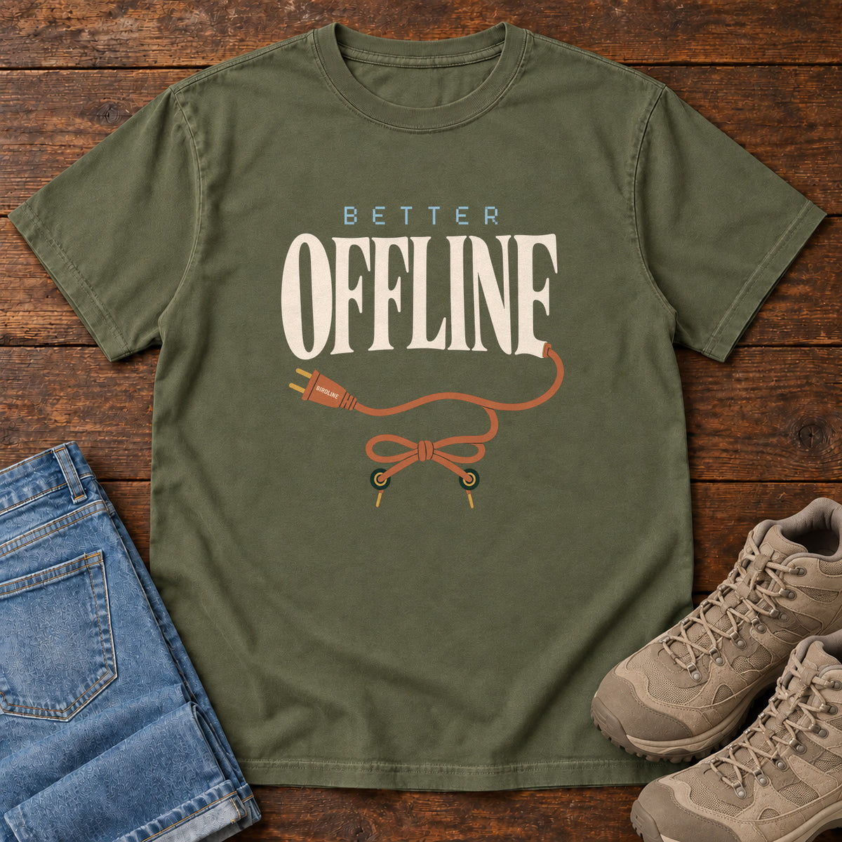 Hemp Better Offline T-Shirt with cream Better Offline lettering and an orange unplugged cord; front flat lay on wood.